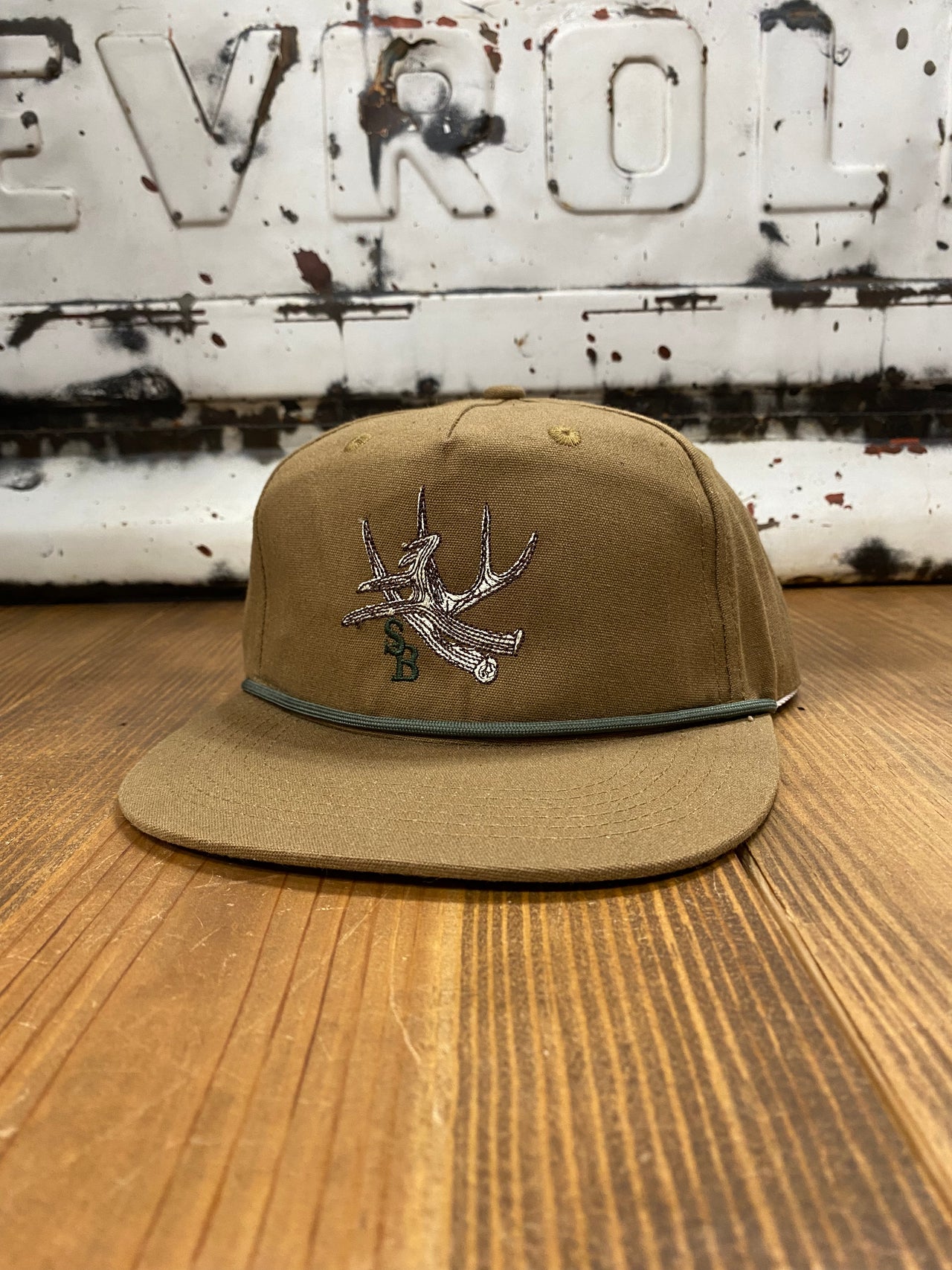 Speckle Bellies Antler Rope Tobacco Color Cap featuring a rustic antler rope design on a 100% cotton base in a earthy tobacco color. Crafted with durable 550 Paracord, mid-crown style, and an adjustable snapback closure for a versatile and stylish outdoor accessory. One Size Fits Most."