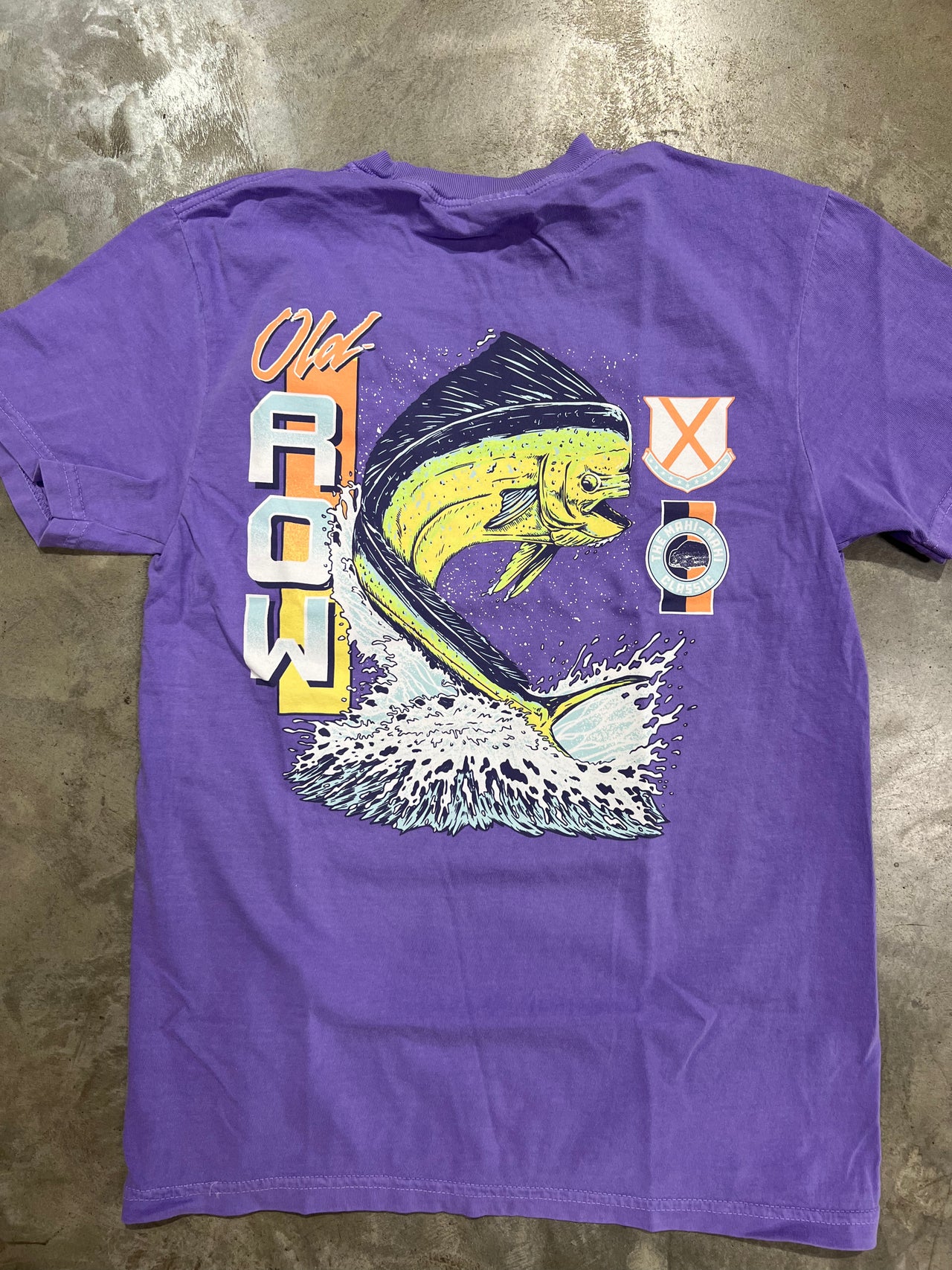 Mahi jumping out of the water on an Old Row Short Sleeve T-shirt in the color Violet.