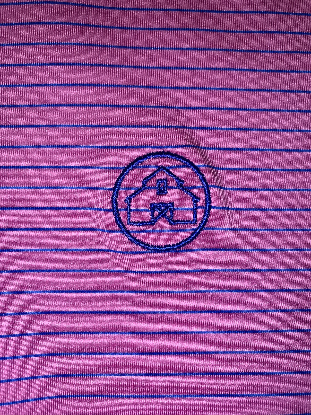 Home Bound Apparel Original Azalea Pink Performance Polo with Thin Cobalt Blue Stripes on a model showcasing vibrant style and comfortable fit for active lifestyles.