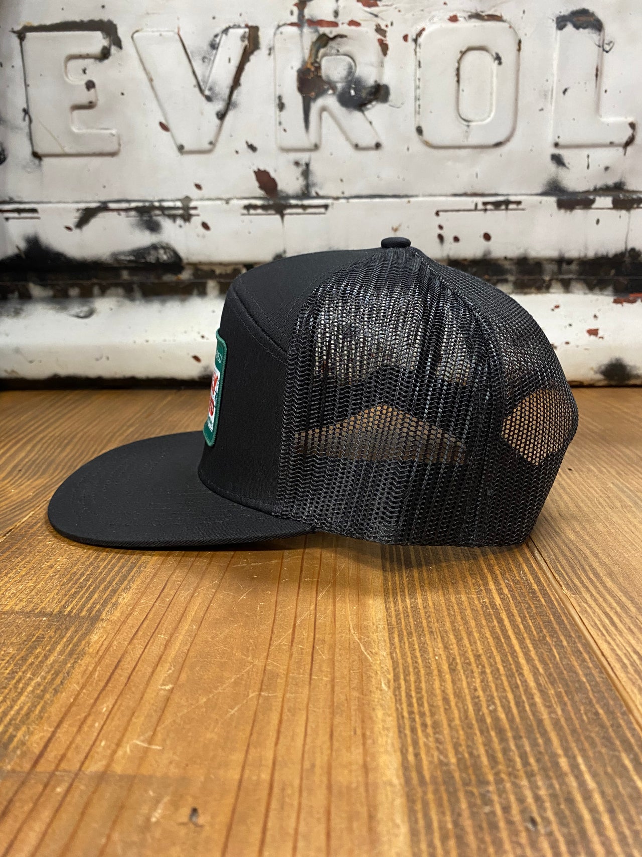 Fully Flocked Black Snapback: A sleek 7-panel cap with a black snapback design, featuring a vibrant red man logo embroidered patch. The epitome of urban sophistication and individual style."