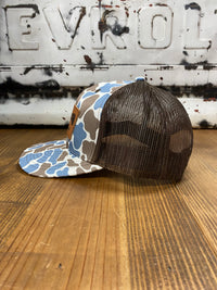Thumbnail for Fully Flocked Blue Old School Camo Snapback Hat featuring a richardson 112 trucker cap style, adorned with a leather patch showcasing elegant flying mallards. The blue old school camo print and brown mesh snapback create a perfect blend of classic and contemporary outdoor fashion.