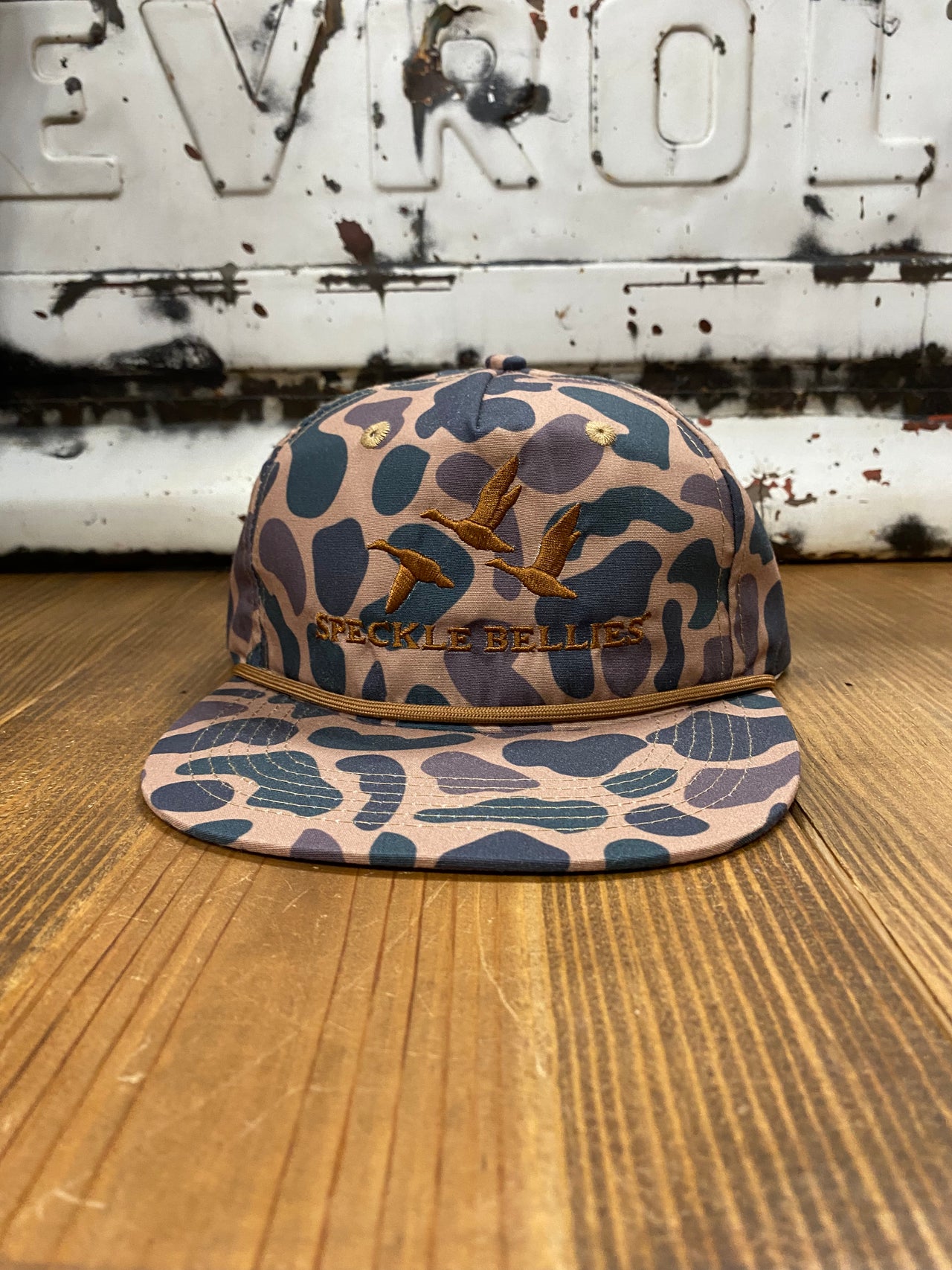 "Speckle Bellies 3 Geese 3D Rope Delta Camo Cap - A 100% cotton, Delta Camo patterned cap with 3D rope detailing of three geese, ideal for outdoor enthusiasts. The cap features a mid-crown design, adjustable snapback closure, and is crafted with durable 550 Paracord for a comfortable and versatile fit. One Size Fits Most."